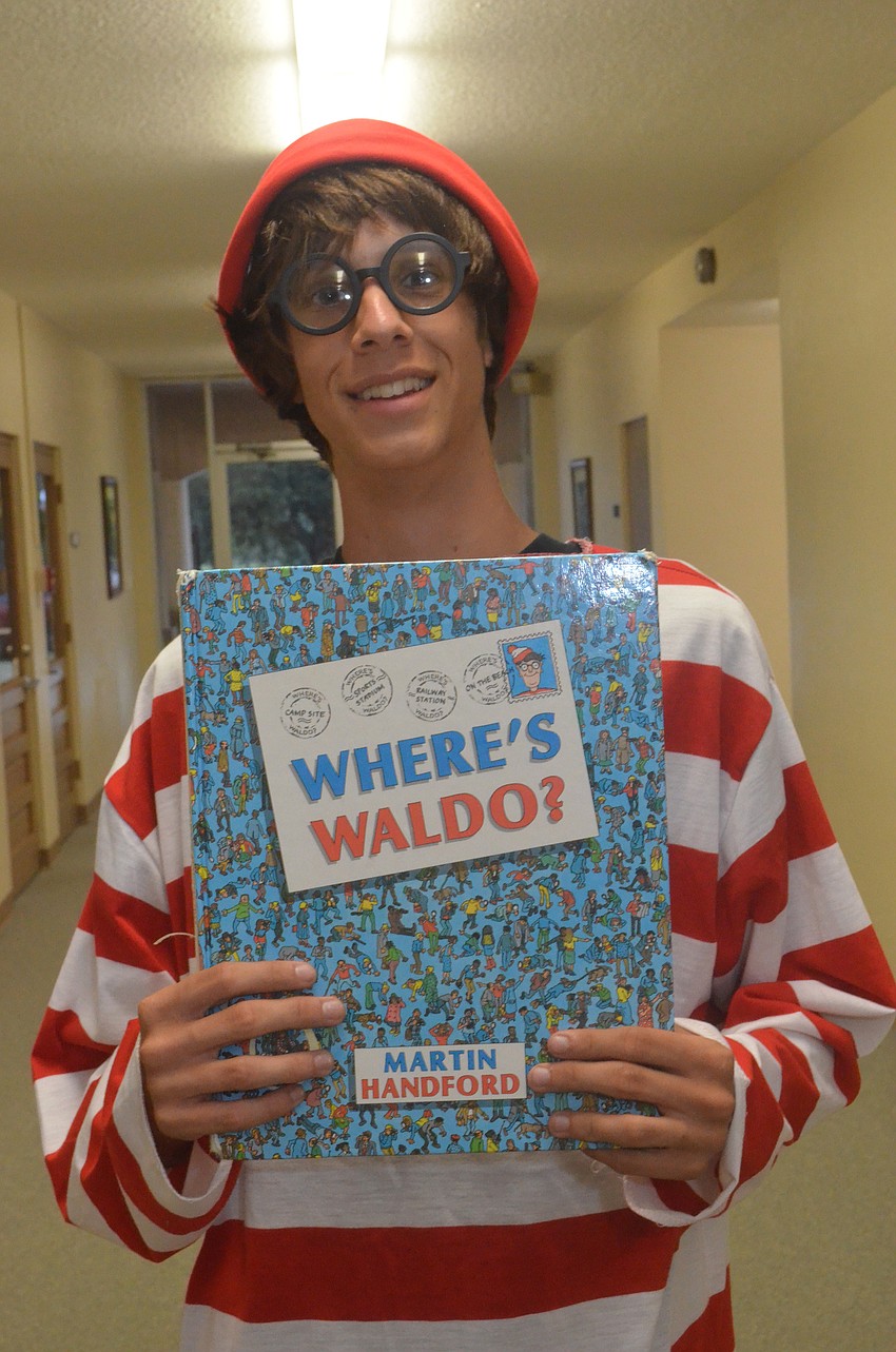 Sarasota High School junior Joshua Jensen volunteers and dresses up like Waldo at the book fair to encourage reading.