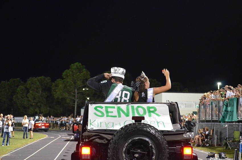 Seniors and King and Queen Wyatt Mcleod and Marina Masterson toss candy to fans.