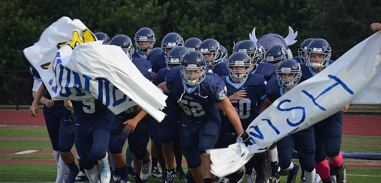 Maxime Provost and his teammates rush out for Friday night football.