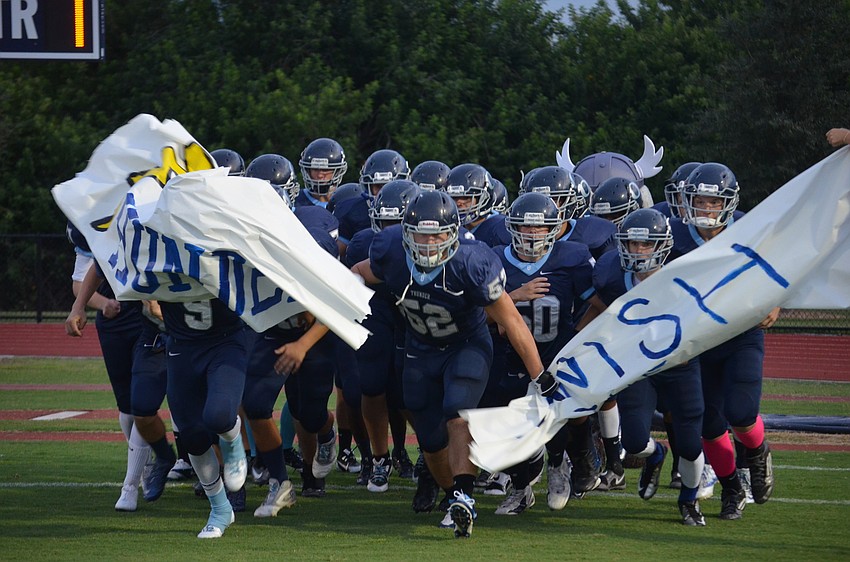 Maxime Provost and his teammates rush out for Friday night football.