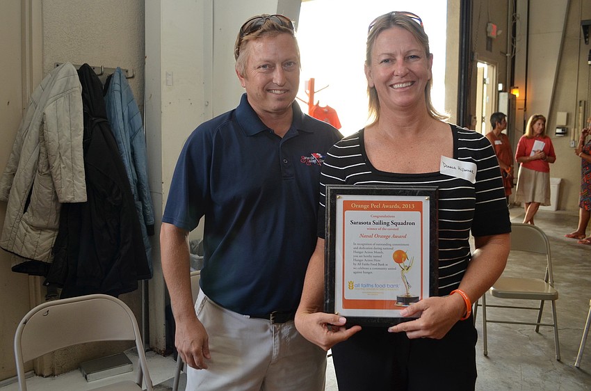 Craig Bridges and Donna Hillmyer receive the award for Sarasota Sailing Squadrons efforts with Hunger Action Month.