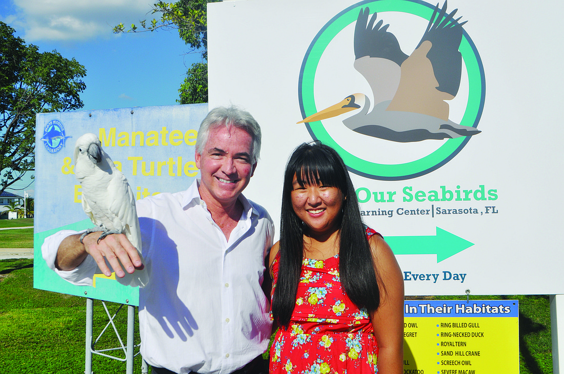 Save Our Seabirds CEO David Pilston, holding Gabby, an umbrella cockatoo, with Ringling student Meghan Kay-Yun Cole