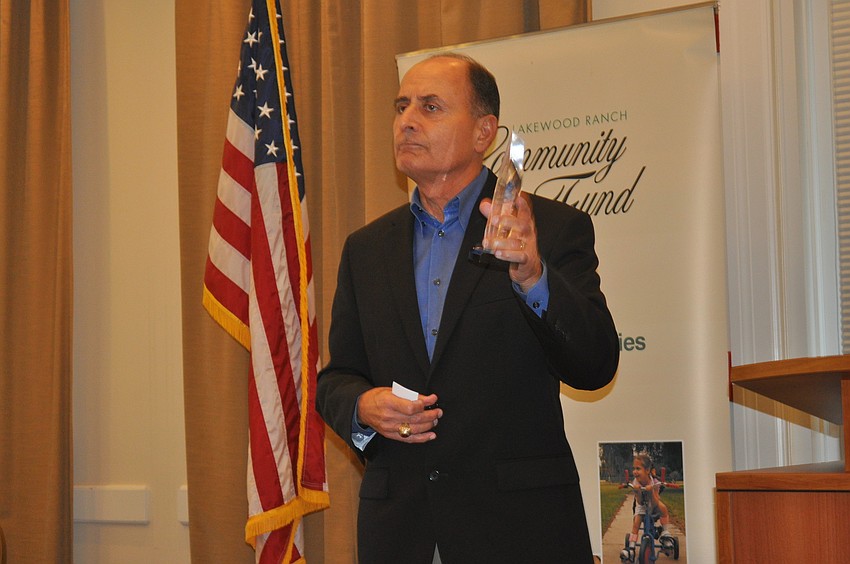 Colonel John W. Saputo, president/owner of Gold Coast Eagle Distributing and former Marine, showed his 2013 C. John A. Clarke Humanitarian Award to the audience.