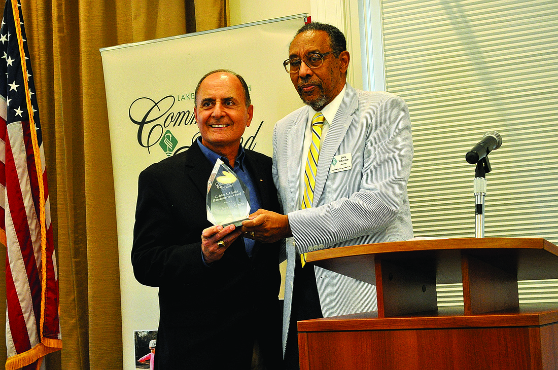 Col. John W. Saputo, president and owner of Gold Coast Eagle Distributing and retired U.S. Marine, accepts the 2013 C. John A. Clarke Humanitarian Award from Dr. Richard Wharton.
