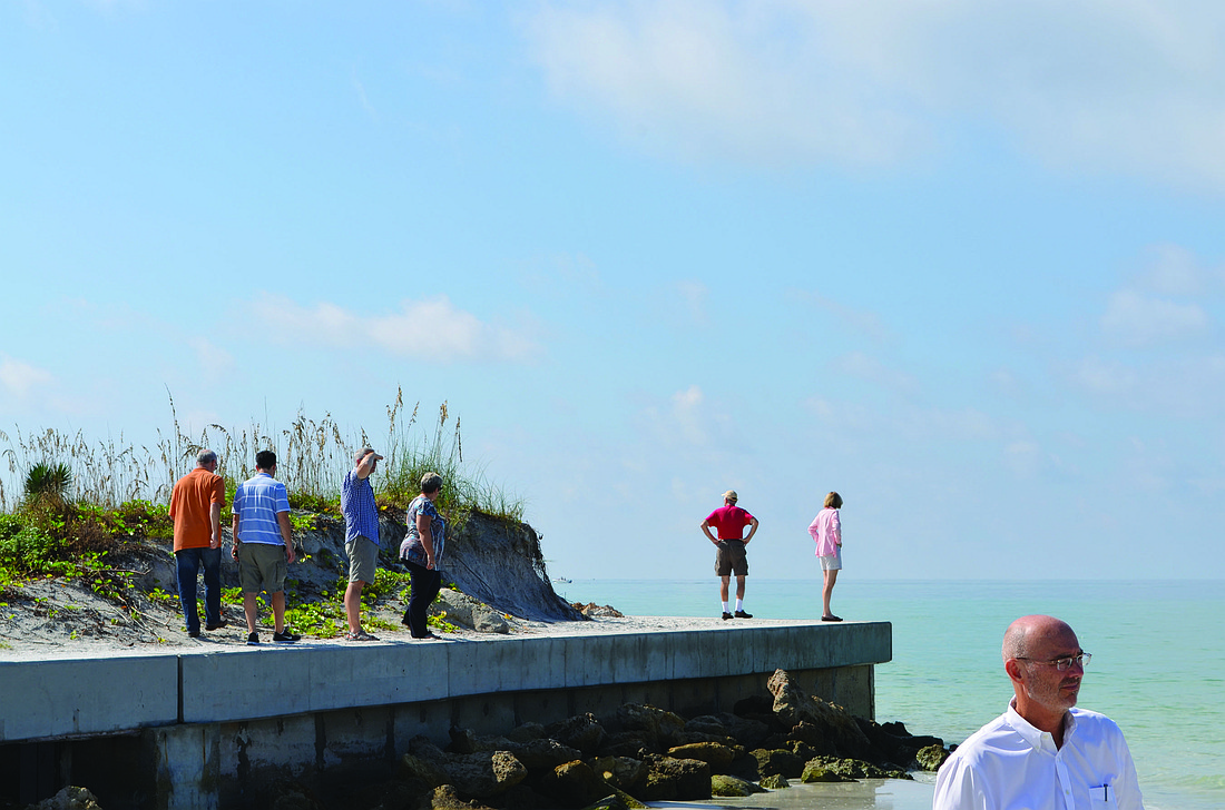 Urban Land Institute panelists walk on top of the North Shore Road beach access seawall, which is severely exposed due to the rapid erosion of sand on the north end of Longboat Key.