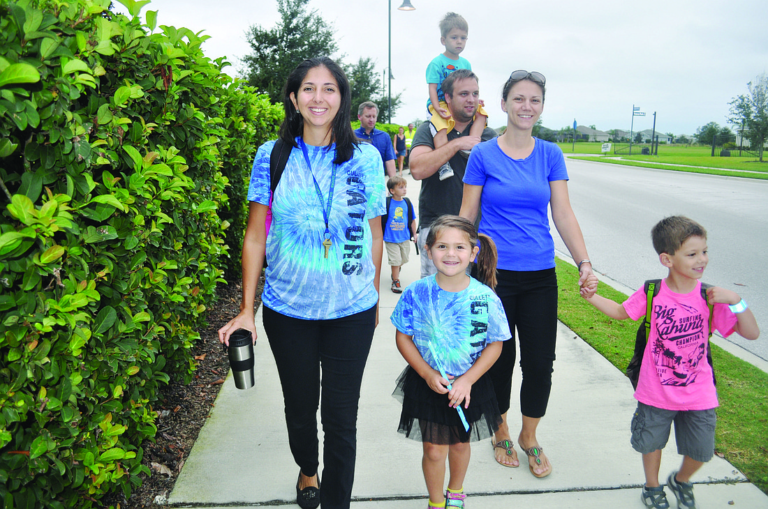 Gullet teacher Jennifer Santora, far left, walks with her daughter, Isabella, near left.