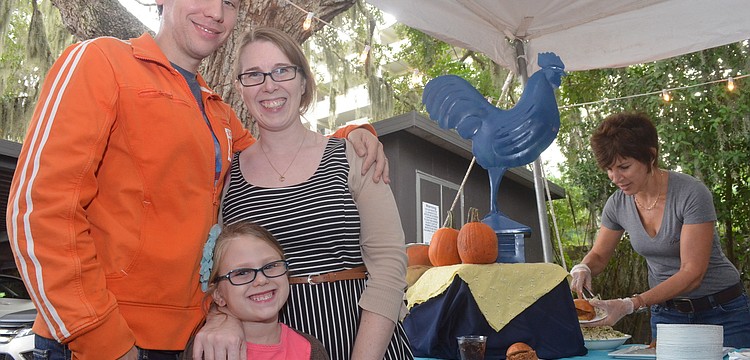 Melissa and Brian Precourt and their daughter Gwendolyn, 5, get ready to sample a Blue Rooster pulled pork slider.