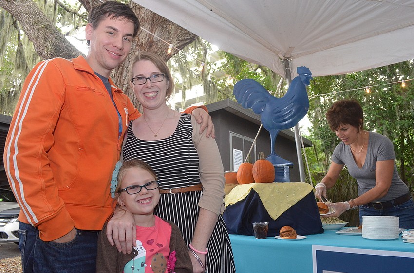 Melissa and Brian Precourt and their daughter Gwendolyn, 5, get ready to sample a Blue Rooster pulled pork slider.