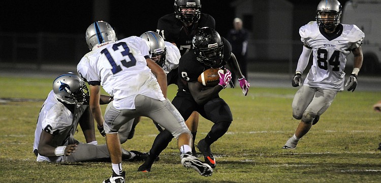 Braden River running back Titus Humphrey carries the ball up the middle for a positive gain.