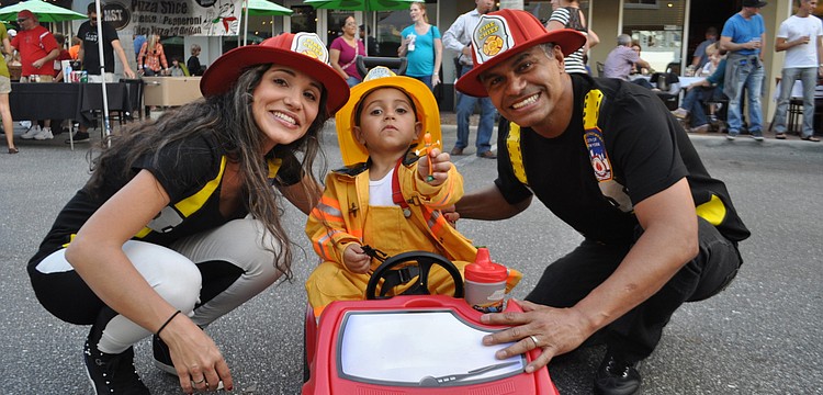 Clara, Miguel and Odimeer Arango all dressed as firemen.