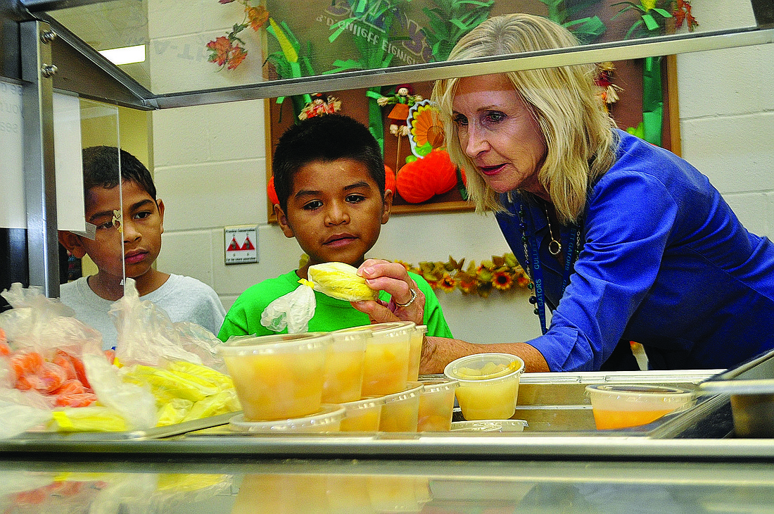 B.D. Gullett Principal Kathy Hayes, right, tries to persuade second-graders Thomas Garcia, 7, and Noe Flores, 8, to try squash.
