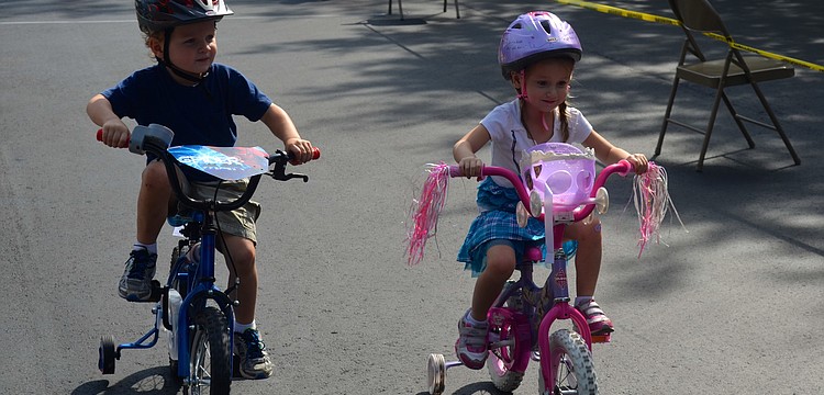 Four-year-olds Luke Ziegler and Camilla Mohammadbhoy race around the lot.