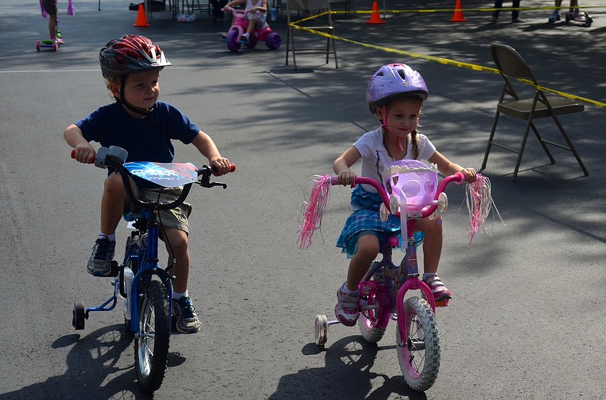 Four-year-olds Luke Ziegler and Camilla Mohammadbhoy race around the lot.