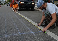 Local chalk artist Truman Adams lays down gridlines for his painting. Adams will be painting a 3-D version of the Statue of Liberty's head.