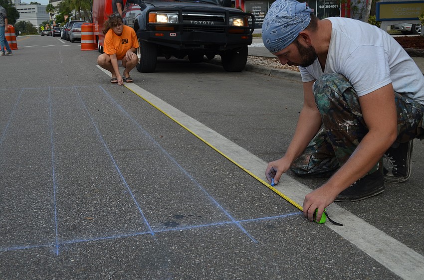 Local chalk artist Truman Adams lays down gridlines for his painting. Adams will be painting a 3-D version of the Statue of Liberty's head.