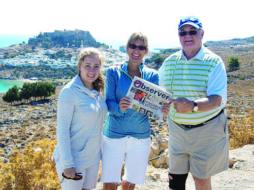 GREECE LIGHTNING. Ashley Munroe, Suzanne Munroe and George Bradicich took their Sarasota Observer along on a trip to Rhodes, Greece, recently. The acropolis of Lindos sits behind them.