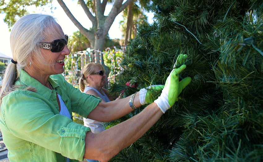 Mary Czernyk and Diana Corrigan work hard to make the tree seem lifelike and full.