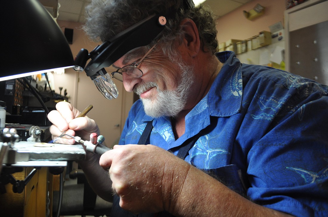 Photo by Pam Eubanks. Stephen Powell, owner of Jewelry by Cole, crafts jewelry at his store on St. Armands Circle.