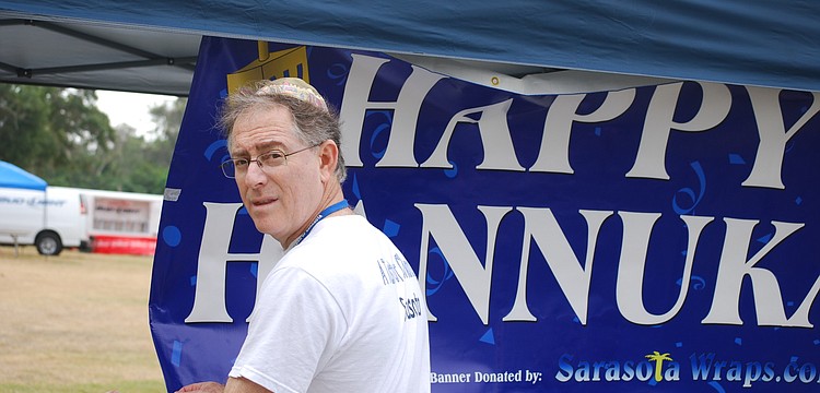 Chabad President and event organizer Dr. Barry Stein hangs a sign.