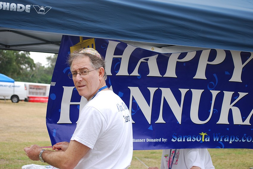 Chabad President and event organizer Dr. Barry Stein hangs a sign.