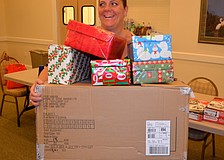 Five-year event participant Kim Guerra balances freshly-wrapped boxes.