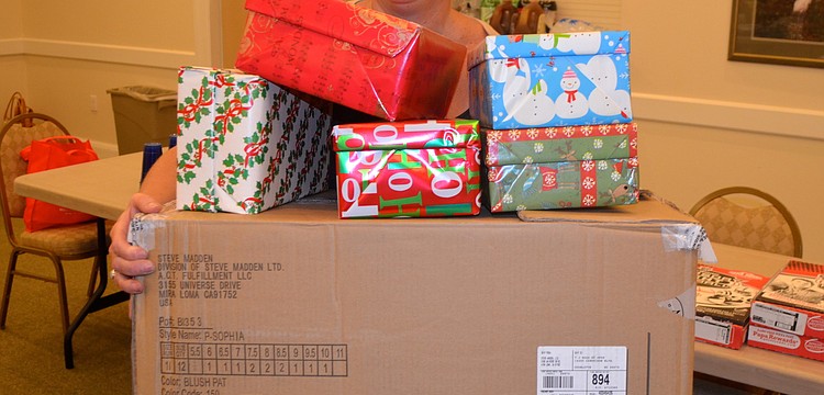 Five-year event participant Kim Guerra balances freshly-wrapped boxes.