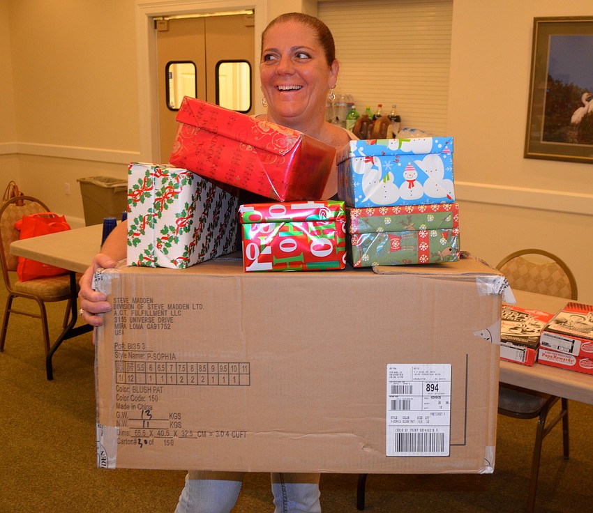 Five-year event participant Kim Guerra balances freshly-wrapped boxes.