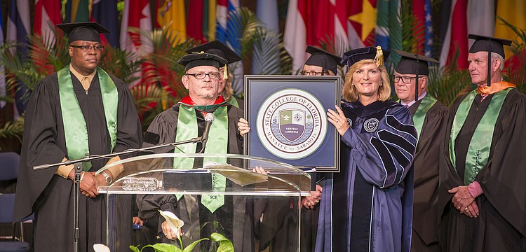 The SCF District Board of Trustees, including Vice Chairman Edward Bailey and Chairman Dr. Craig Trigueiro, present the college seal to President Dr. Carol F. Probstfeld during the inauguration ceremony.