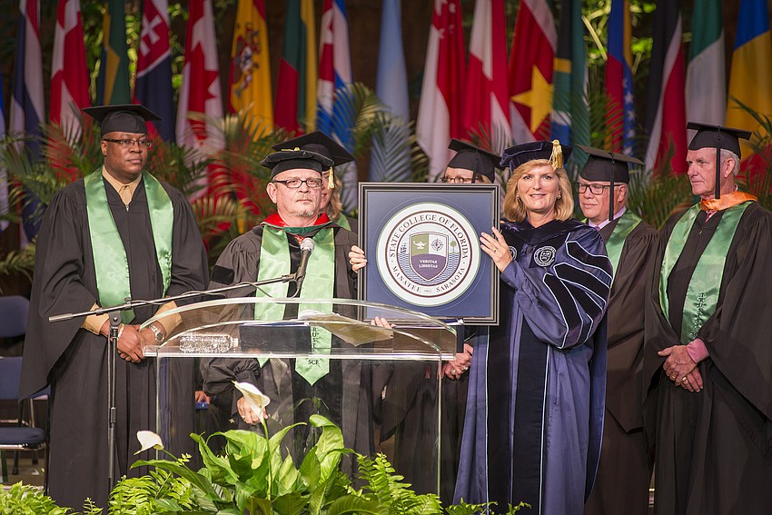 The SCF District Board of Trustees, including Vice Chairman Edward Bailey and Chairman Dr. Craig Trigueiro, present the college seal to President Dr. Carol F. Probstfeld during the inauguration ceremony.