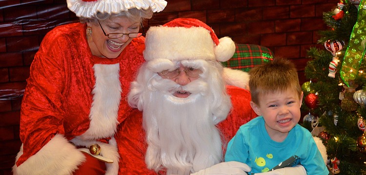 Mrs. and Mr. Clause laugh at three-year-old Cole Tillsonâ€™s spunk.