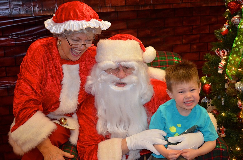 Mrs. and Mr. Clause laugh at three-year-old Cole Tillsonâ€™s spunk.