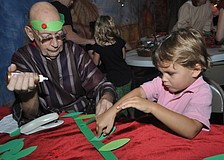 Bill Hansing helps Harrison Phillips, 5, make a victory wreath.