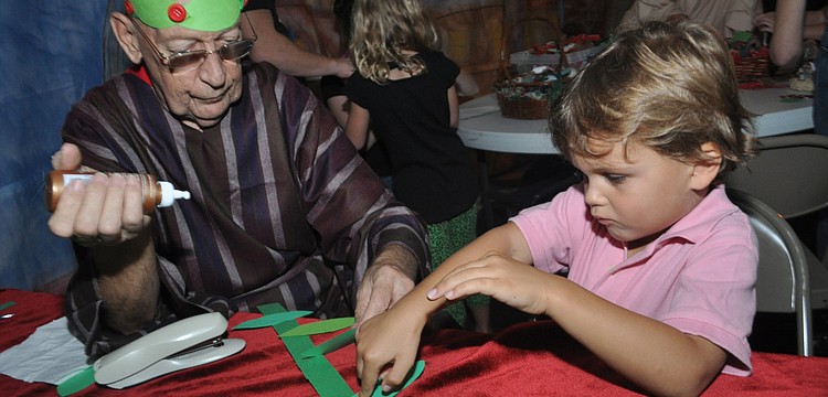 Bill Hansing helps Harrison Phillips, 5, make a victory wreath.