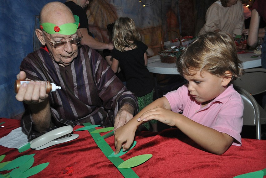Bill Hansing helps Harrison Phillips, 5, make a victory wreath.