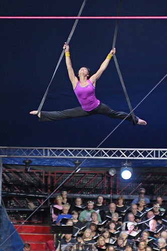 An aerial trapeze artist performs over the heads of the Key Chorale members. (Courtesy Photo).