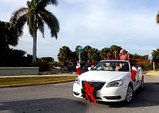 During the parade, Jeanne Miller waves to the crowd from the Dockside Marine Service car.