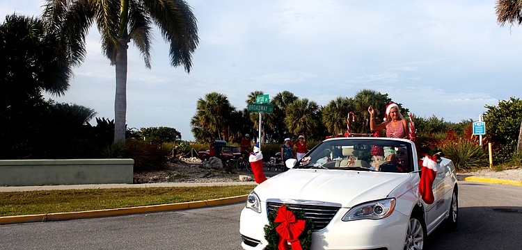 During the parade, Jeanne Miller waves to the crowd from the Dockside Marine Service car.