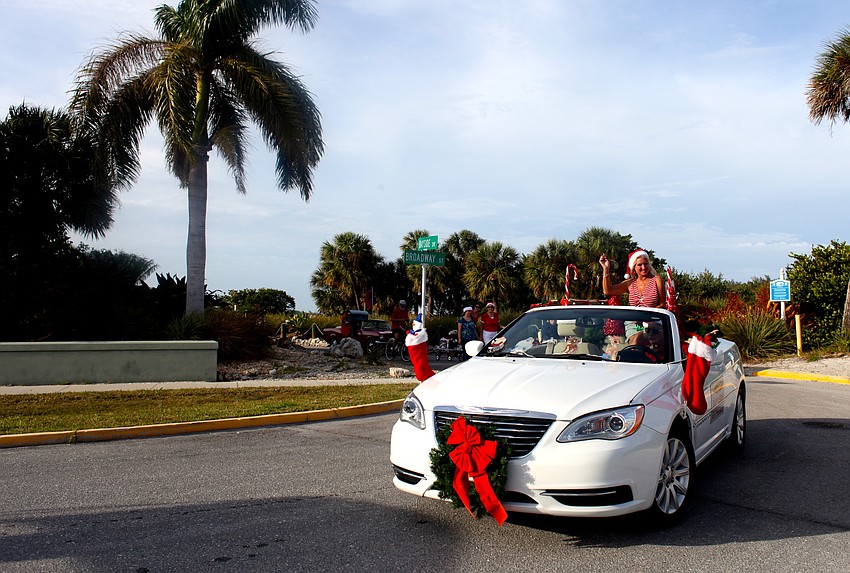 During the parade, Jeanne Miller waves to the crowd from the Dockside Marine Service car.