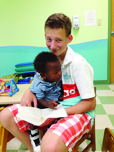 Anton Sroka with a child from the day care SCS students visited on their trip.