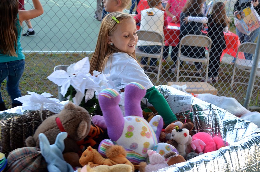 Ava Mcleod, 8, reaches in to pick out her favorite stuffed animal.