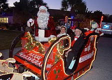 John and Millie Emond, as Mr. and Mrs. Claus, and Bill Crocker play dress up for their neighbors.