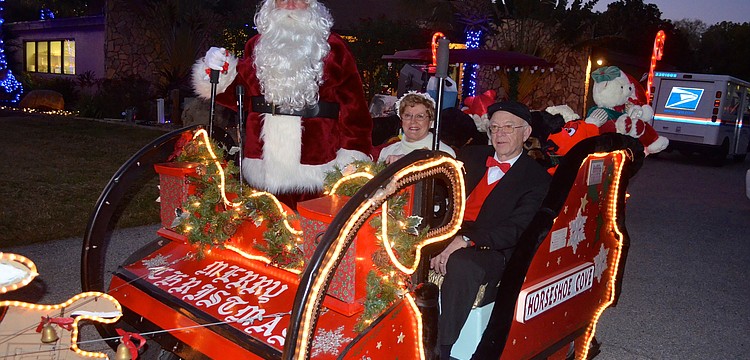 John and Millie Emond, as Mr. and Mrs. Claus, and Bill Crocker play dress up for their neighbors.