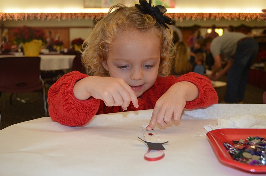 Molly Harris works hard on her snowman ornament.