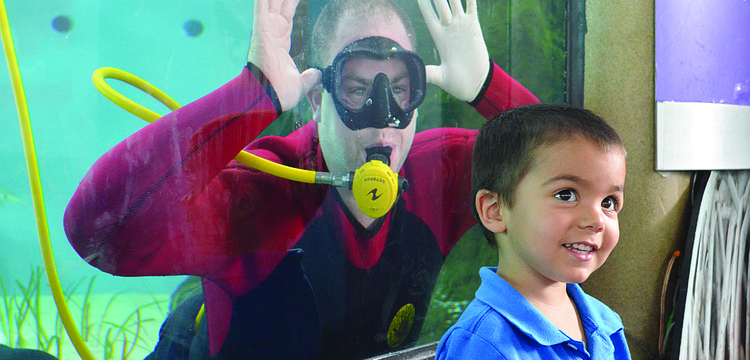 Nathan Alderman smiles with a diver in the background at Mote Marine's World Oceans Day Family Festival June 8. 6