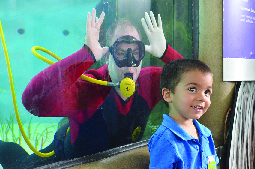 Nathan Alderman smiles with a diver in the background at Mote Marine's World Oceans Day Family Festival June 8. 6