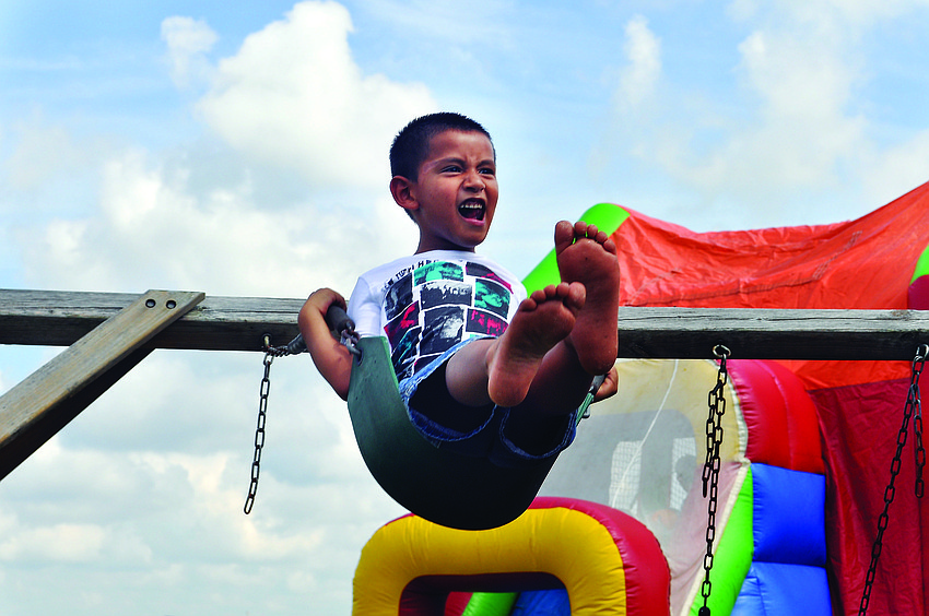 Joshua Zuniger swings as high as he can  during a celebration of the first anniversary of Bayside Community Church's East Sarasota campus Sept. 8.