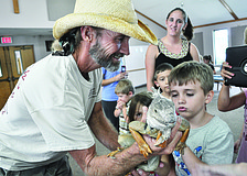 Justin Matthews, of Justin Matthews Wildlife Rescue, shows children Causeway, an iguana, July 26 at All God's Children Preschool, at Living Lord Lutheran Church.