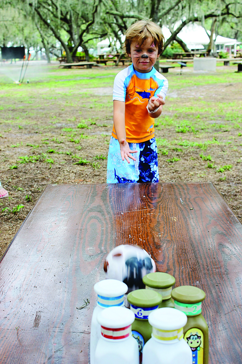 Vincent D'Amato plays a milk bottle bowling game during Dakin Dairy's family fun day June 15. 2