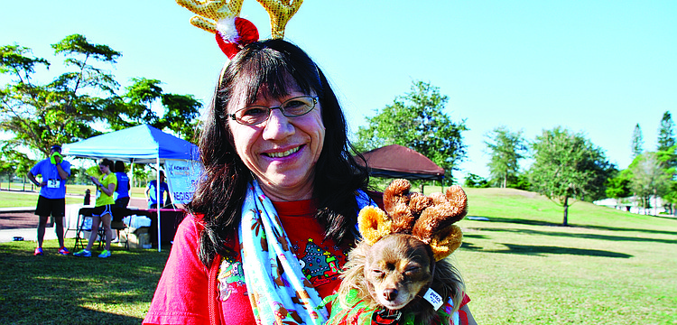 Chris Deluna with her dog, Kiwi, at the third annual Achieva Reindeer Trot Dec. 7, at Payne Park.