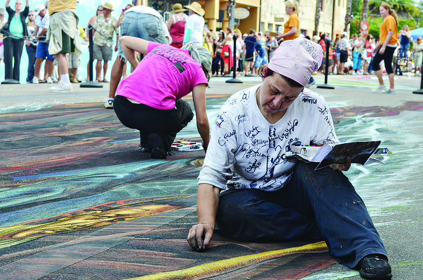 Artist Ketty Grossi works on her chalk art during the 2013 